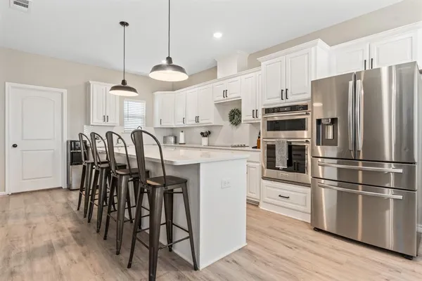 a kitchen with granite countertop white cabinets white stainless steel appliances and a sink