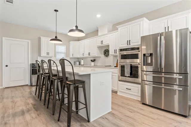 a kitchen with granite countertop white cabinets white stainless steel appliances and a sink