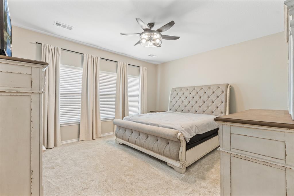 130 Private Road Hillsboro, TX 76645 - Photo 17 of 39 a bedroom with a large bed and a ceiling fan