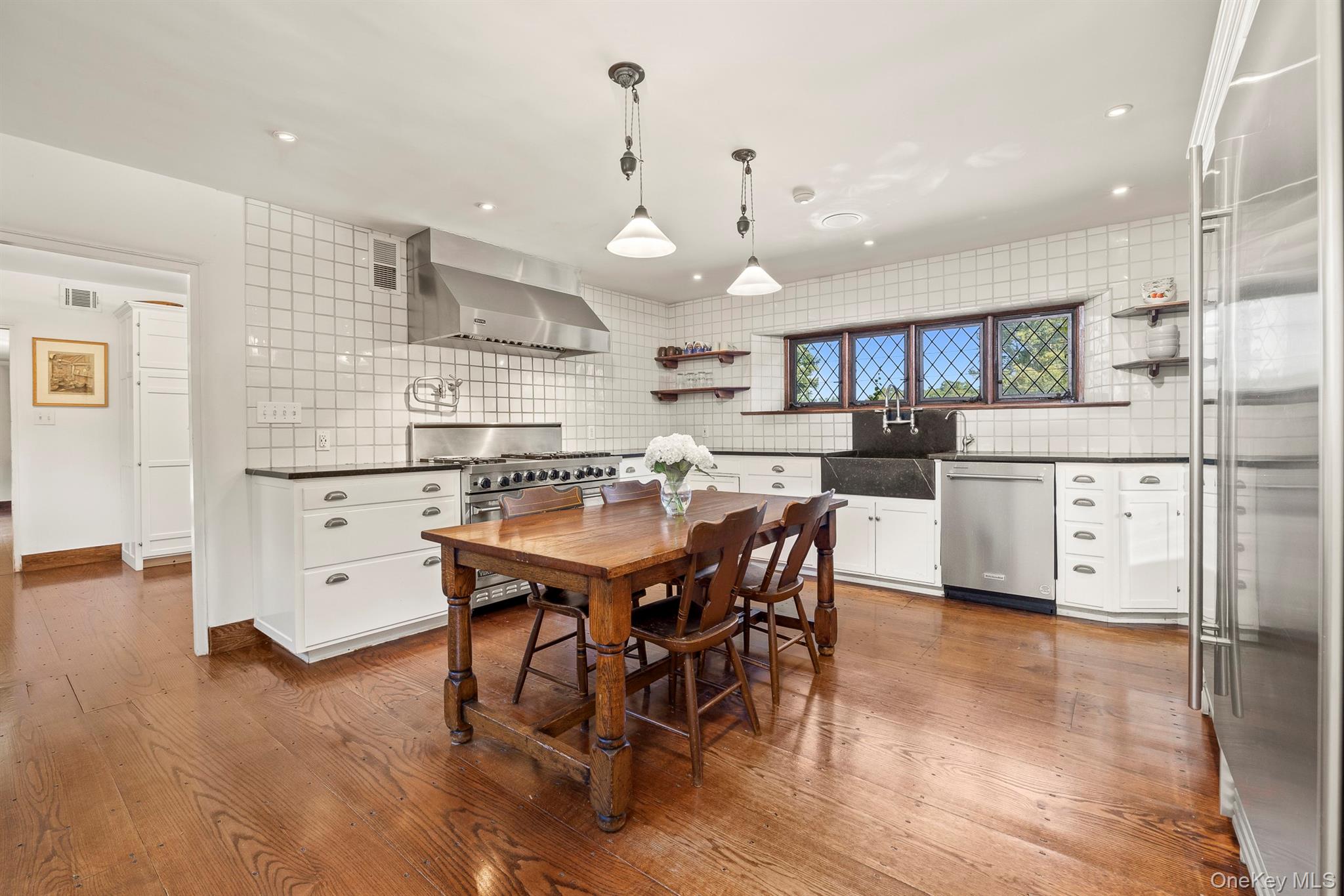 99 Quaker Bridge Road Croton-on-Hudson, NY 10520 - Photo 11 of 50 a kitchen with stainless steel appliances kitchen island granite countertop a sink a stove a dining table and chairs