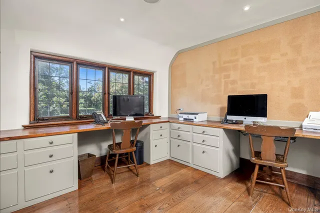 a view of a workspace with furniture and a window