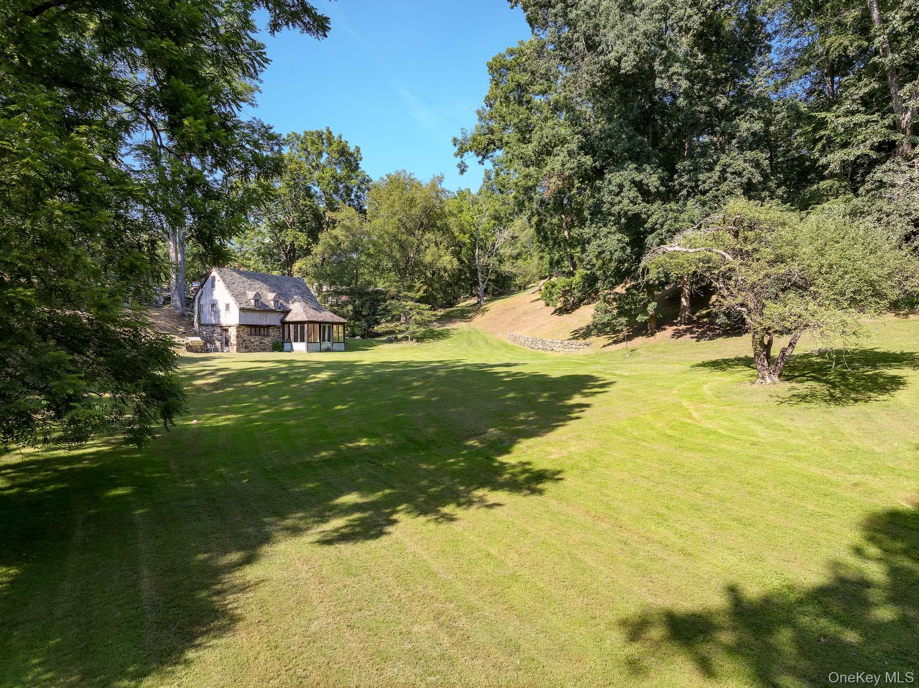 99 Quaker Bridge Road Croton-on-Hudson, NY 10520 - Photo 36 of 50 a backyard of a house with a yard and large trees