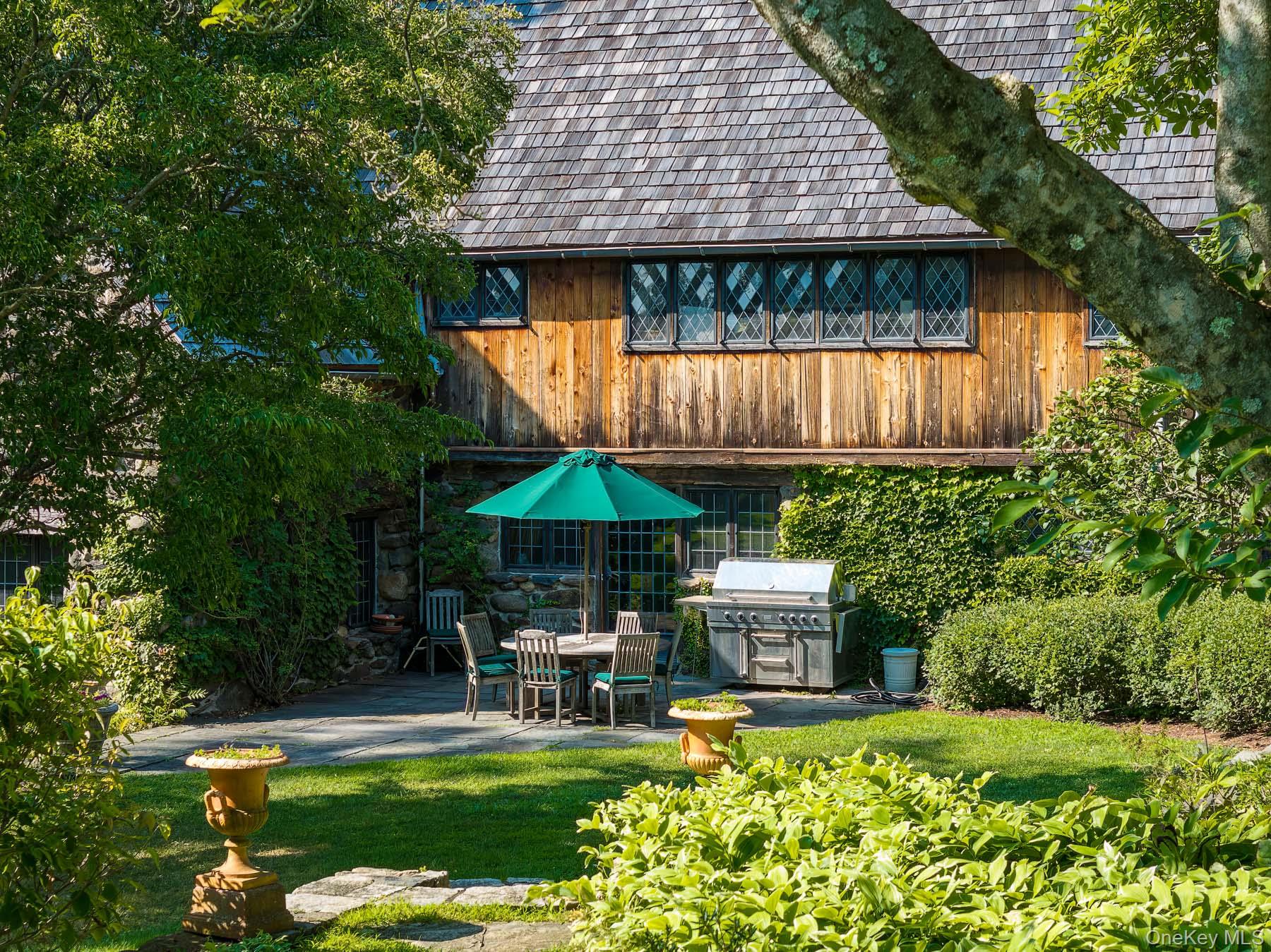 99 Quaker Bridge Road Croton-on-Hudson, NY 10520 - Photo 8 of 50 a view of a table and chairs under an umbrella in patio