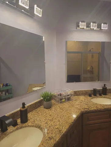 a bathroom with a granite countertop sink and a mirror
