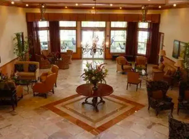 a living room with furniture a floor to ceiling window and a flat screen tv