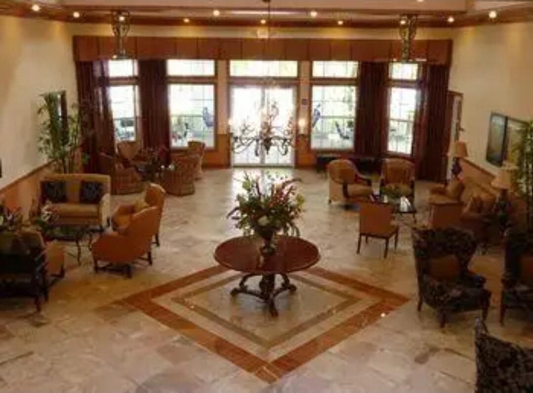 9770 Bowline Drive, Unit 102 West Palm Beach, FL 33411 - Photo 15 of 27 a living room with furniture a floor to ceiling window and a flat screen tv