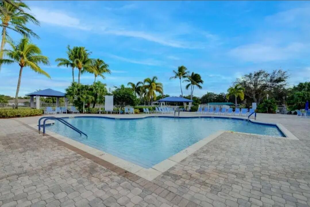 9770 Bowline Drive, Unit 102 West Palm Beach, FL 33411 - Photo 18 of 27 a view of a swimming pool with an outdoor seating