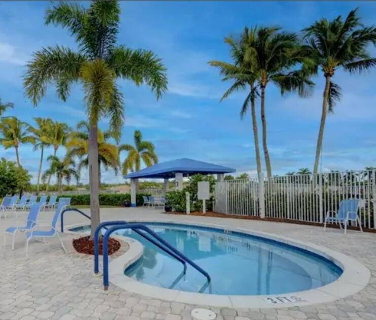 9770 Bowline Drive, Unit 102 West Palm Beach, FL 33411 - Photo 19 of 27 a view of swimming pool with a table and chairs