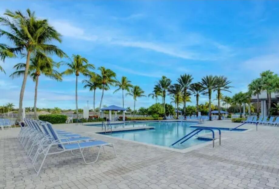 9770 Bowline Drive, Unit 102 West Palm Beach, FL 33411 - Photo 20 of 27 a view of swimming pool with a table and chairs
