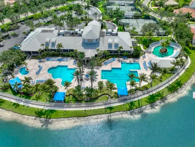 an aerial view of a house with a garden and lake view