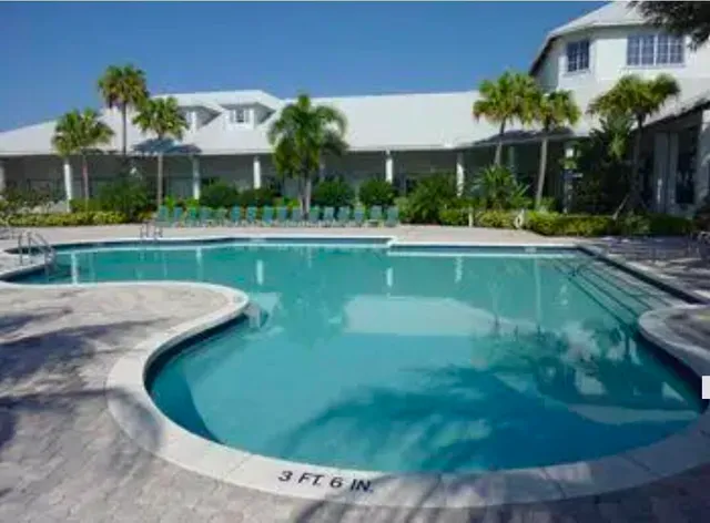 a view of a house with a swimming pool and a yard
