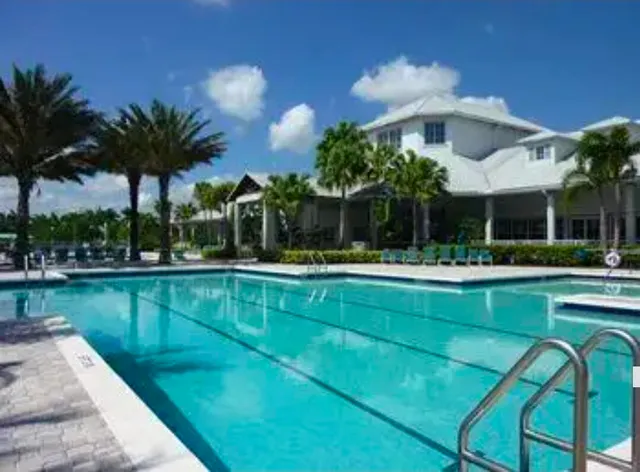 a view of a swimming pool with a table and chairs under an umbrella