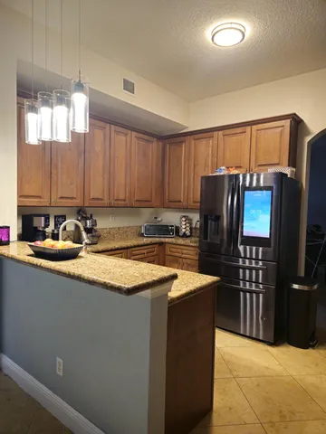 a kitchen with stainless steel appliances granite countertop a sink and a refrigerator