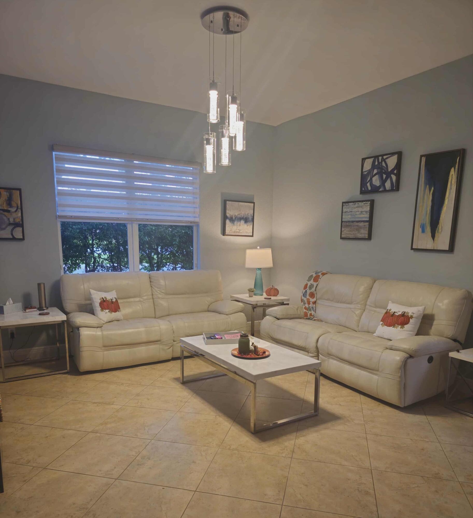 9770 Bowline Drive, Unit 102 West Palm Beach, FL 33411 - Photo 5 of 27 a living room with furniture chandelier and a large window