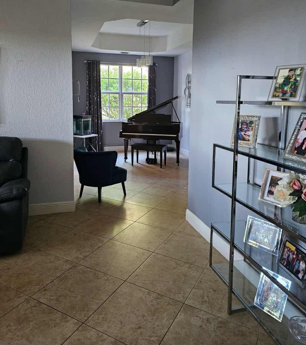 9770 Bowline Drive, Unit 102 West Palm Beach, FL 33411 - Photo 8 of 27 a living room with furniture a piano and a window