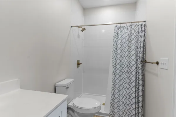 a white toilet sitting next to a shower curtain