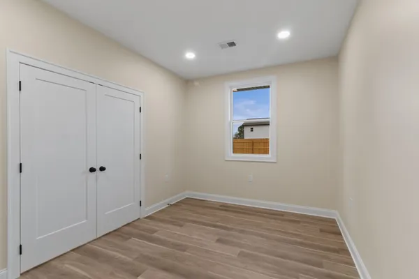 a view of an empty room with wooden floor