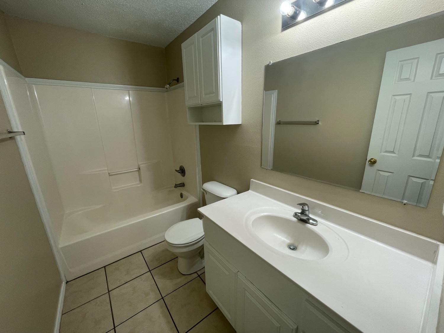 5827 6th Street, Unit A Lubbock, TX 79416 - Photo 10 of 10 a bathroom with a sink a toilet and shower