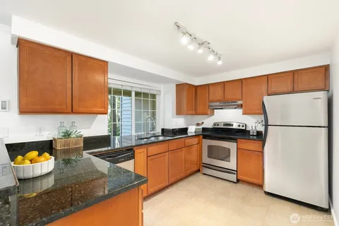 a kitchen with stainless steel appliances granite countertop a sink stove and refrigerator
