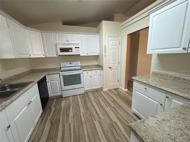 a kitchen with a sink stove and refrigerator