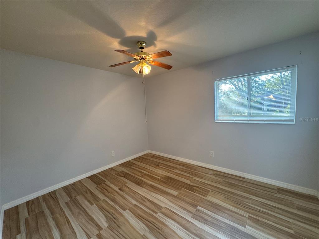 5440 Southwest 100th Loop Ocala, FL 34476 - Photo 18 of 37 a view of empty room with wooden floor and fan