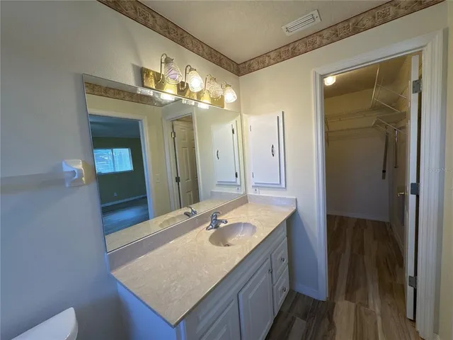a bathroom with a granite countertop sink and a mirror
