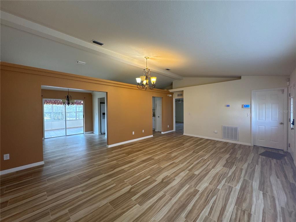 5440 Southwest 100th Loop Ocala, FL 34476 - Photo 5 of 37 a view of an empty room with wooden floor and a window