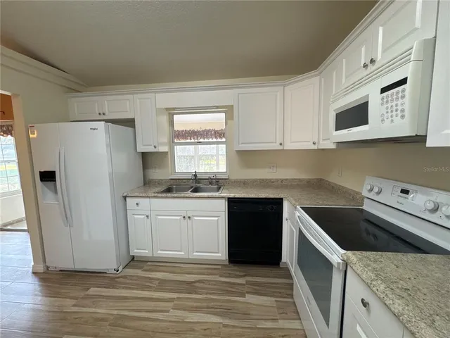a kitchen with granite countertop a refrigerator and a stove