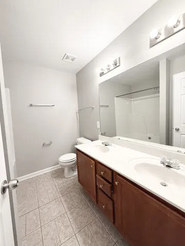 a bathroom with a granite countertop sink mirror vanity and toilet