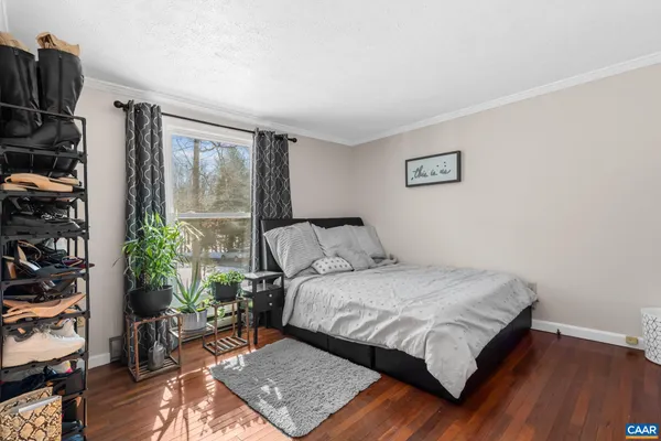 a bedroom with a bed a bookshelf and a potted plant