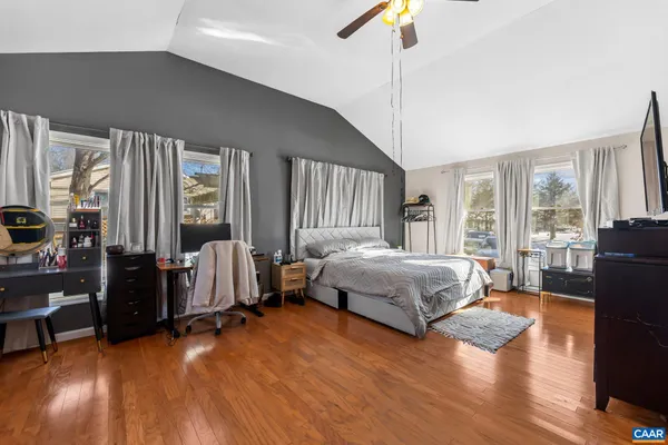 a spacious bedroom with a bed and wooden floor