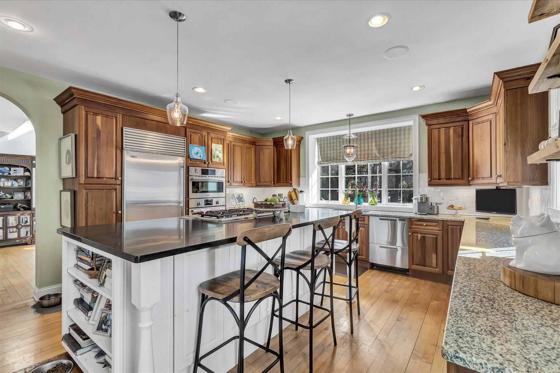 77 The Heights Mashpee, MA 02649 - Photo 18 of 52 a kitchen with stainless steel appliances granite countertop a stove refrigerator and chairs