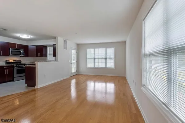 a view of a kitchen with wooden floor and a window