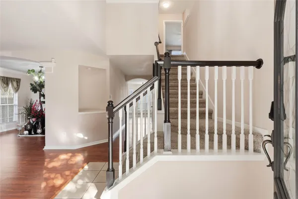 a view of staircase with lots of frames on wall and a large window