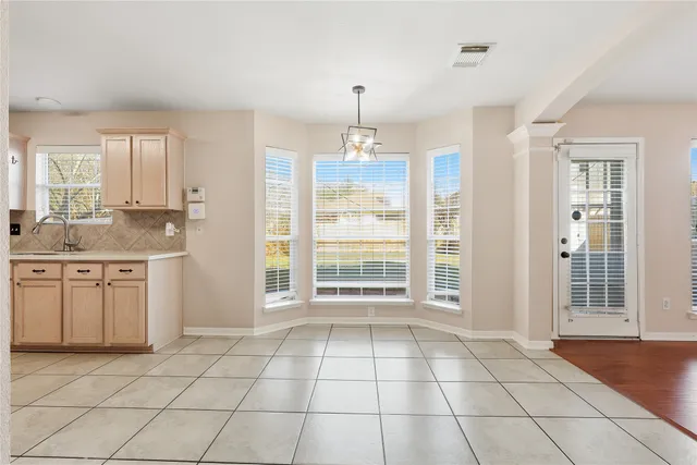 a open kitchen with granite countertop a stove a sink dishwasher and a refrigerator with white cabinets