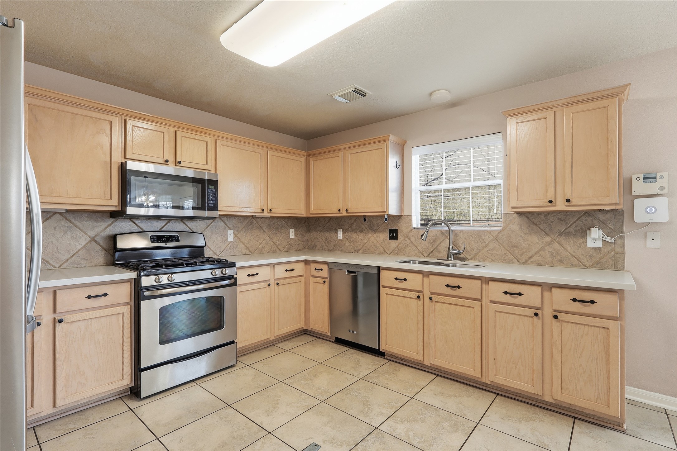 503 Elm Ridge Drive Spring, TX 77386 - Photo 8 of 21 a kitchen with cabinets stainless steel appliances and a window