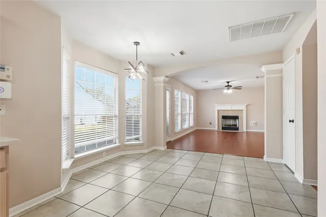 a view of an empty room with window and wooden floor