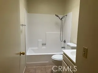a bathroom with a granite countertop bathtub shower sink vanity and toilet