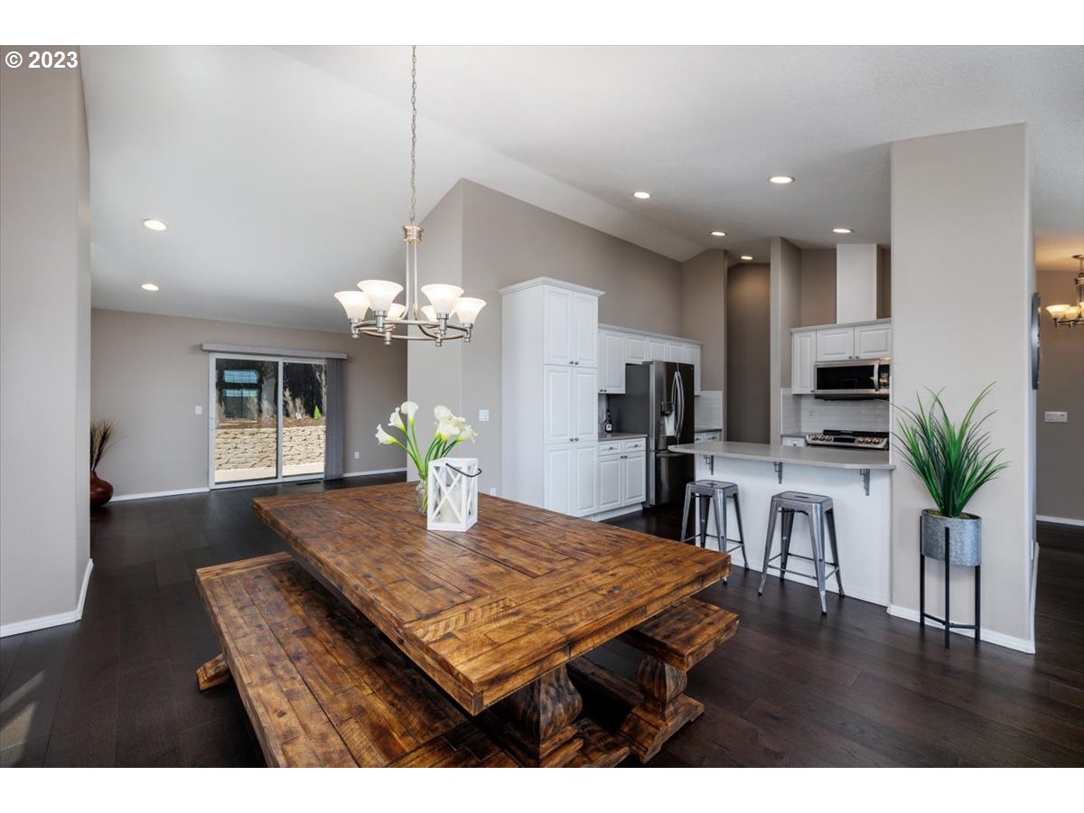 15855 Southwest Colyer Way Portland, OR 97224 - Photo 12 of 37 a view of a dining room and livingroom with furniture wooden floor a chandelier