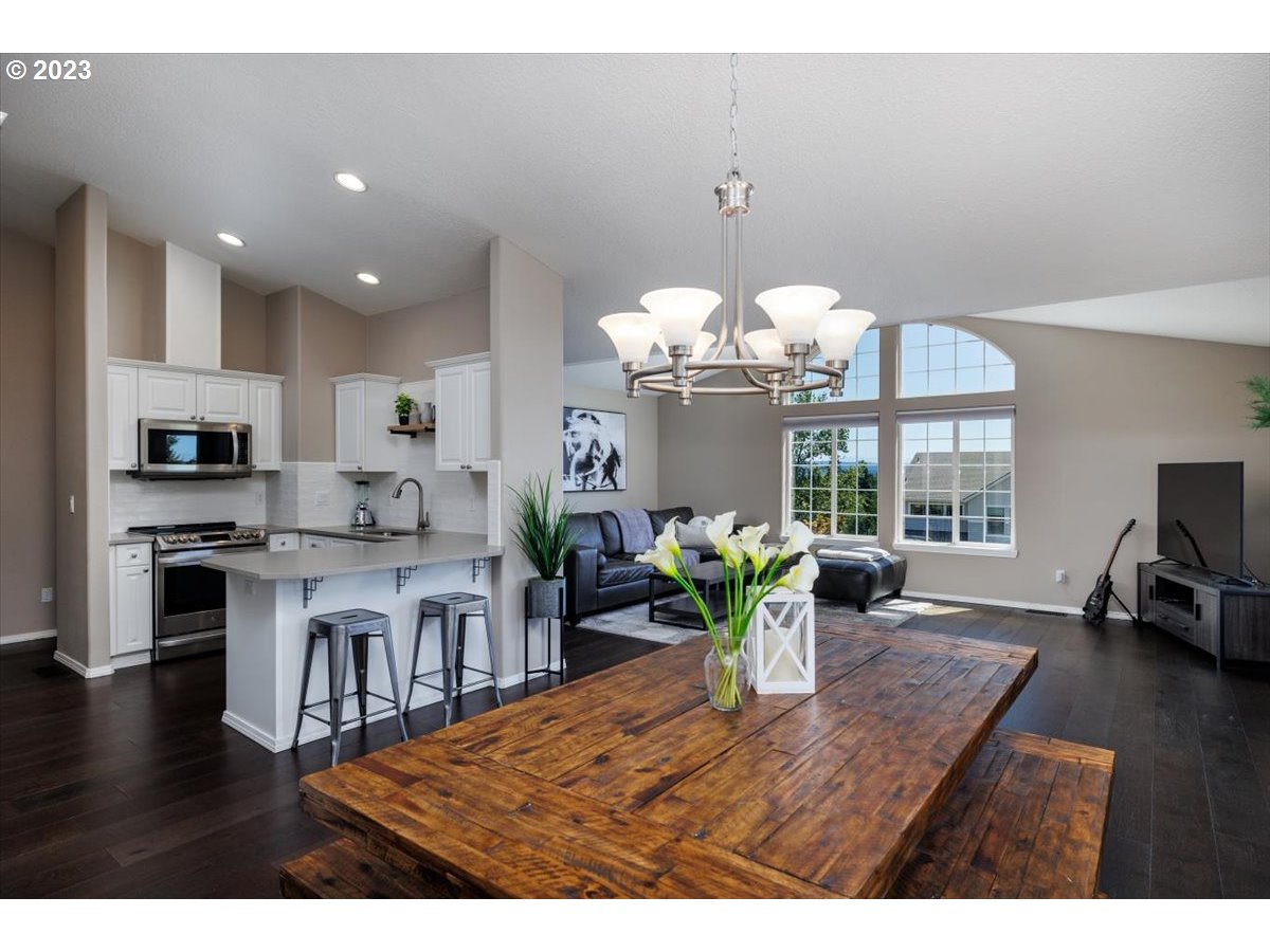 15855 Southwest Colyer Way Portland, OR 97224 - Photo 13 of 37 a kitchen view with stainless steel appliances granite countertop a sink dishwasher and microwave with wooden floor