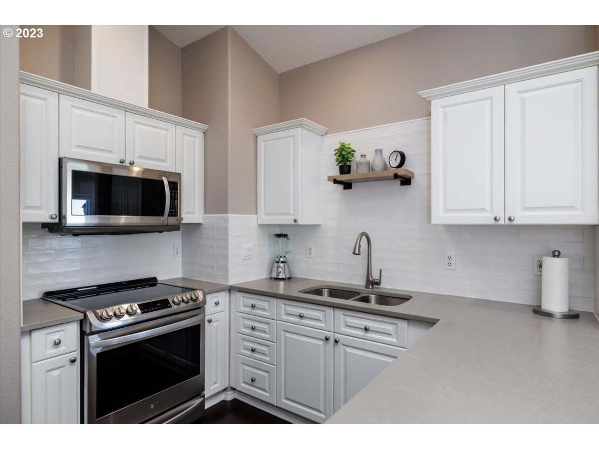 15855 Southwest Colyer Way Portland, OR 97224 - Photo 15 of 37 a kitchen with stainless steel appliances white cabinets and a stove top oven