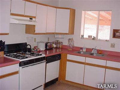 1024 Avenida Ciervo Rio Rico, AZ 85648 - Photo 6 of 8 a kitchen with stainless steel appliances a stove a sink cabinets and a window