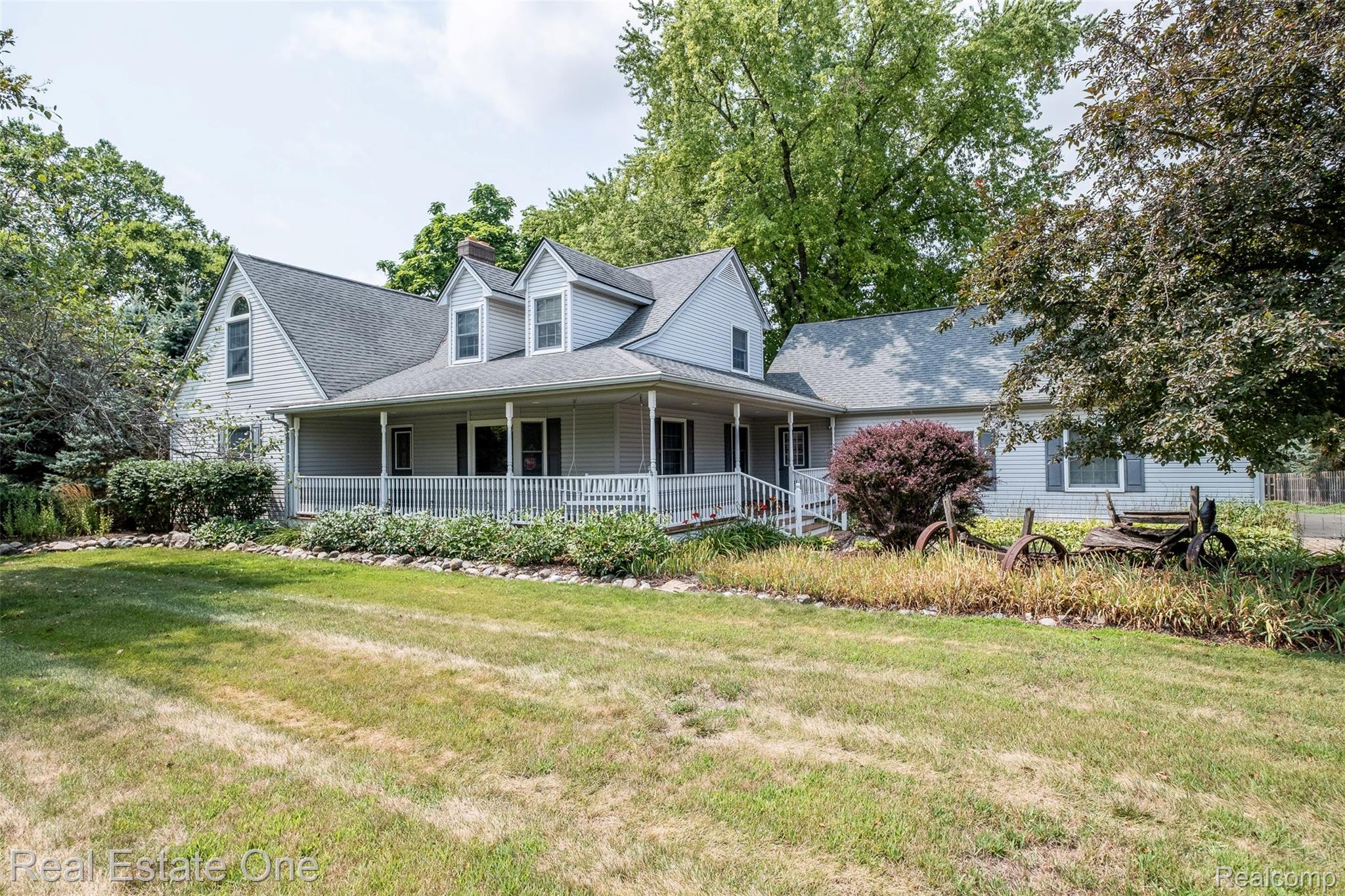 11030 Marshall Road South Lyon, MI 48178 - Photo 10 of 83 Classic farmhouse-style residence featuring a wraparound front porch with columns, peaked gable roofline with dormer windows, and white exterior siding