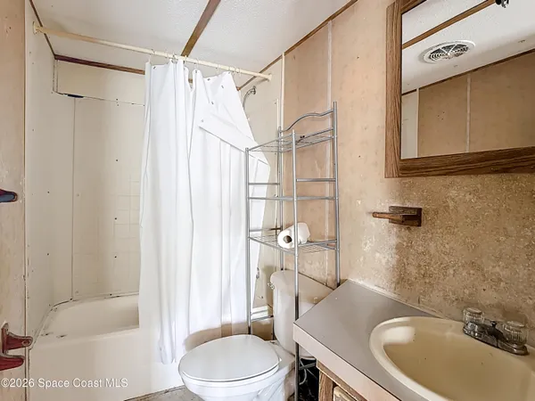 a en suite bathroom with a granite countertop sink and a mirror