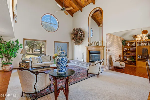 a living room with furniture a fireplace and lots of windows