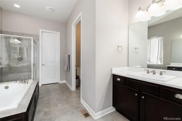 a spacious bathroom with a bathtub sink and mirror