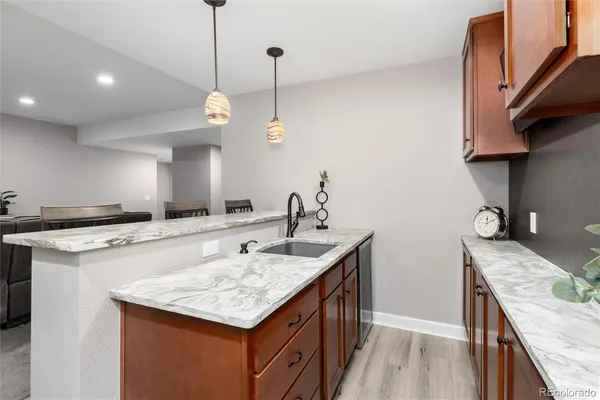 a kitchen with kitchen island granite countertop a sink and a stove