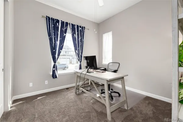a view of a workspace with furniture and a window