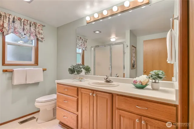 a bathroom with a toilet a sink and mirror