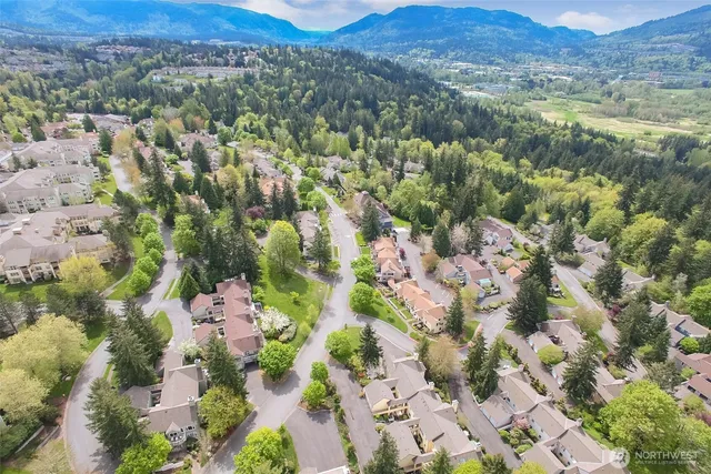 an aerial view of residential house with parking and trees